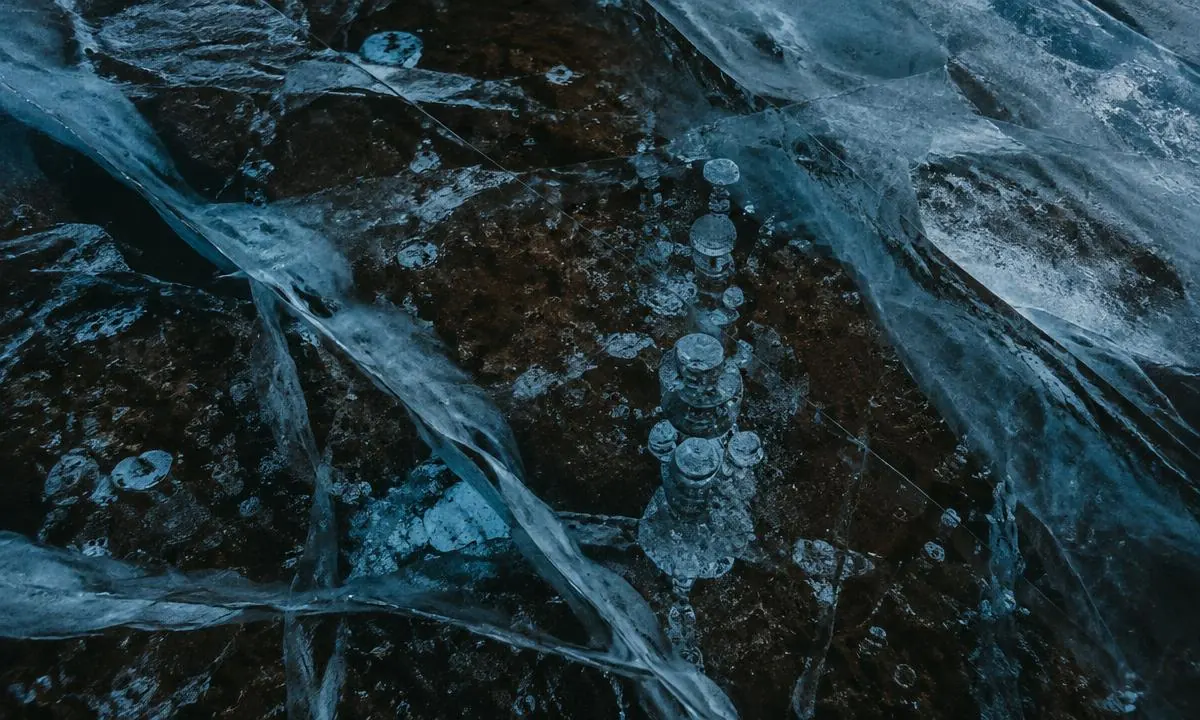 Eis mit eingeschlossenen Luftblasen und Rissen, von oben fotografiert